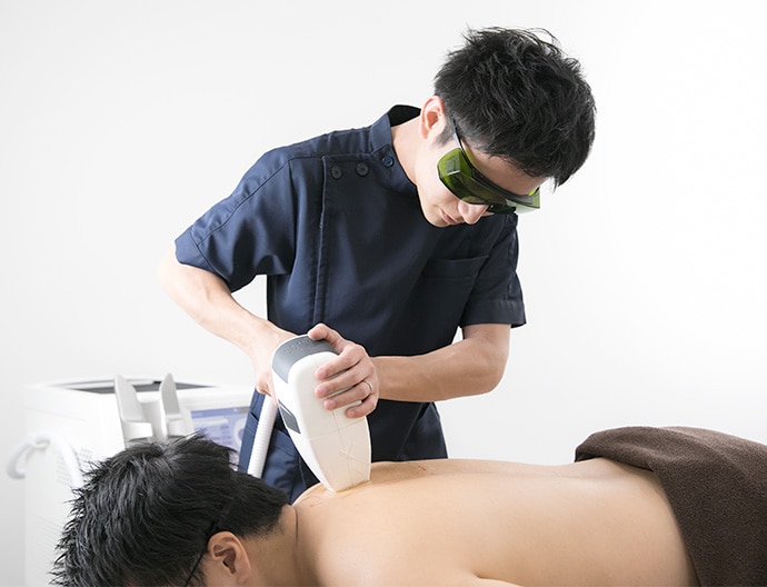 医療脱毛レーザー照射を行う男性看護師スタッフ